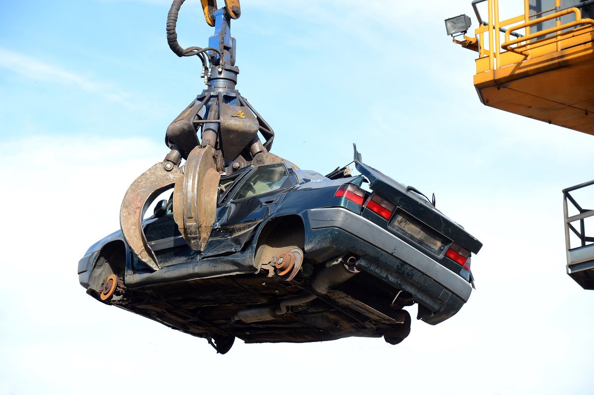 Pinza meccanica che solleva un'auto destinata alla demolizione